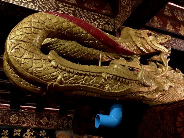 Inside the main temple of Xieng Thong, I spotted a horizontal beam hanging from the ceiling. It was painted in gold and had carvings of dragons on both ends. On one end, I noticed a blue plastic plumbing stuck to the bottom of it. I guess this must be where they collect dragon piss. 