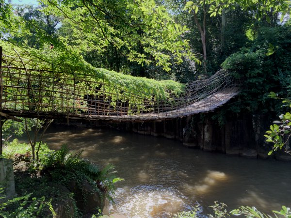 Crossing this creaking suspension bridge made of wood and rattan.